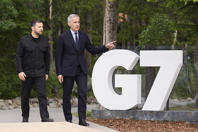 볼로디미르 젤렌스키 우크라이나 대통령(왼쪽)이 17일(현지시간) 캐나다 앨버타주 캐내내스키스에서 열린 주요 7개국(G7) 정상회의 회의장으로 가기 위해 마크 카니 캐나다 총리와 이동하고 있다. AP연합뉴스