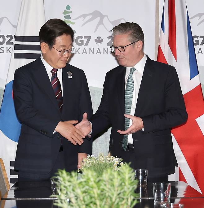 이재명 대통령이 17일(현지시간) 캐나다 앨버타주 캐내내스키스 주요 7개국(G7) 정상회의장에서 키어 스타머 영국 총리와 한영 정상회담 전 악수하고 있다. 연합뉴스