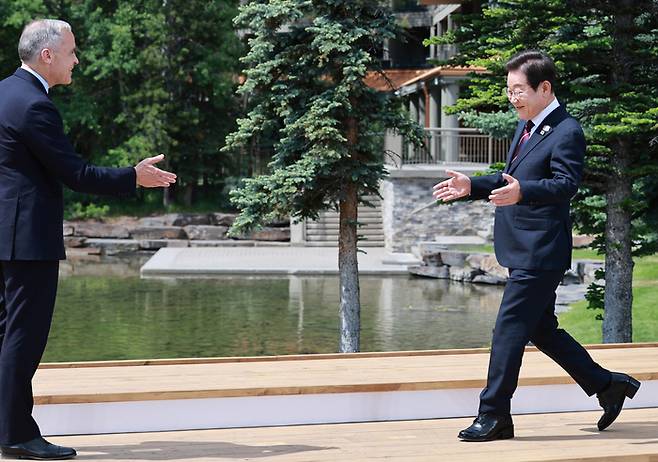 이재명 대통령이 17일(현지시간) 캐나다 앨버타주 캐내내스키스 주요 7개국(G7) 정상회의장에서 열린 초청국 공식 환영식에 도착해 의장국 마크 카니 캐나다 총리와 인사하고 있다.  대통령실 사진기자단