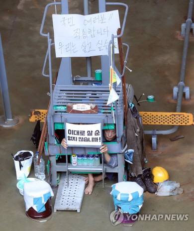 유최안 금속노조 거제통영고성조선하청지회 부지회장이 2022년 7월 19일 경남 거제시 아주동 대우조선해양(현 한화오션) 옥포조선소 독 화물창 바닥 구조물 안에서 피켓을 들고 있다. 연합뉴스