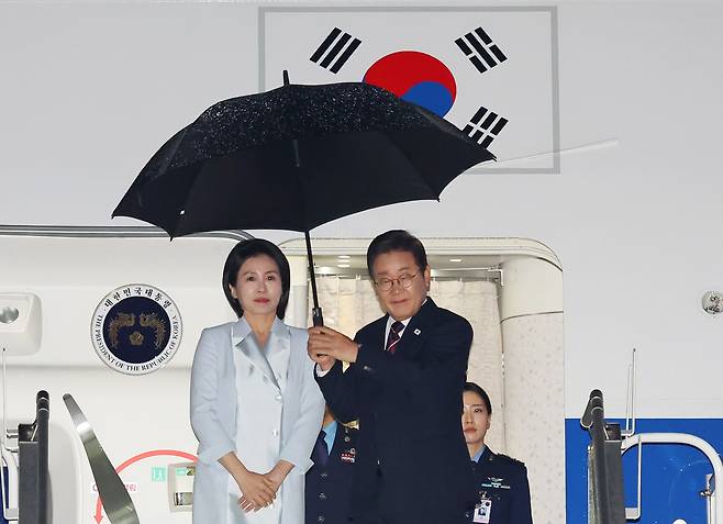 이재명 대통령과 김혜경 여사가 17일(현지시간) 51차 주요 7개국(G7) 정상회의 일정을 마치고 캐나다 캘거리국제공항에서 귀국하며 공군 1호기에 오르고 있다. [연합]