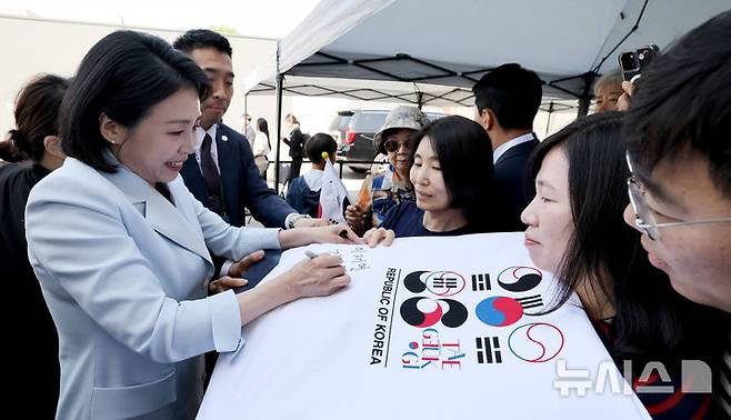 [캘거리=뉴시스] 최진석 기자 = 이재명 대통령 부인 김혜경 여사가 17일(현지 시간) 캐나다 앨버타주 캘거리 한인회관에서 열린 캐나다 서부 동포사회와의 대화를 나누기 전 인사하며 티셔츠에 싸인을 하고 있다. 2025.06.18. myjs@newsis.com