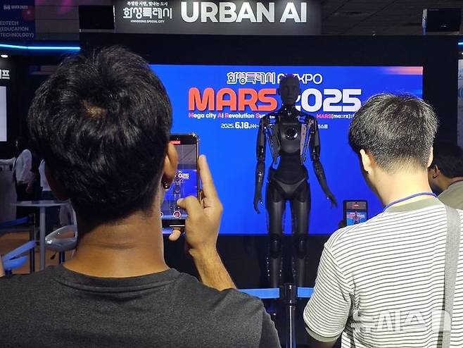 [서울=뉴시스]문영호 기자=경기 화성시가 18일 서울 코엑스 C홀에서 인공지능(AI) 엑스포 'MARS 2025'를 개최한 가운데, 관람객들이 아메카를 촬영하고 있다.2025.06.18.sonanom@newsis.com