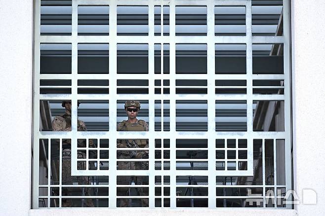 [로스앤젤레스=AP/뉴시스]로스앤젤레스 시내 메트로폴리탄 구치소에서 17일(현지시각) 미군 1명이 경비를 서고 있다. 캐런 배스 로스앤젤레스 시장이 17일(현지시각) 도널드 트럼프 대통령의 이민 단속에 반대하는 야간 시위 중 기물 파손과 침입을 막기 위해 시행했던 통금령을 해제했다. 10일 통금령 선포 1주일 만이다. 2025.06.18.