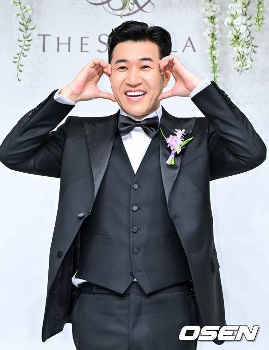 [OSEN=박준형 기자] 가수 김종민은 20일 서울 중구 장충동 신라호텔 영빈관에서 11살 연하 예비 신부와 결혼식을 올린다.예비 신부가 비연예인인 만큼 혼자 포토월에 서는 김종민은 간단한 인터뷰에 응하며 간단한 소감을 전했다. 김종민이 포즈를 취하고 있다.   2025.04.20 / soul1014@osen.co.kr