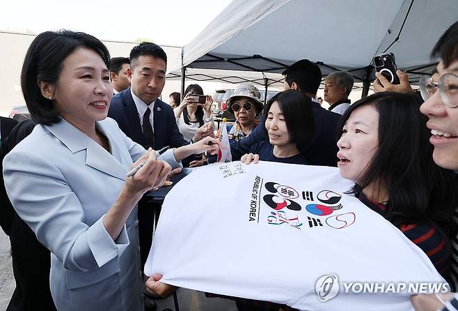 김혜경 여사, 캘거리 한인회 방문 (캘거리[캐나다]=연합뉴스) 한상균 기자 = G7 정상회의에 참석하는 이재명 대통령과 함께 캐나다를 방문한 김혜경 여사가 17일(현지시간) 캘거리 한인회관에서 환영나온 주민들의 요청에 티셔츠에 서명하고 있다. 2025.6.18 xyz@yna.co.kr