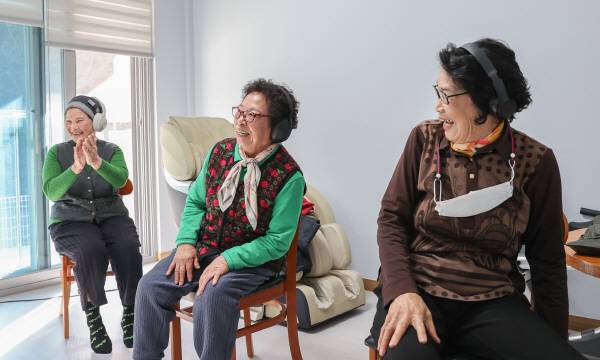 헤드셋을 쓴 채 문제를 듣고 답하는 '고요 속의 외침' 퀴즈에 도전을 연습 중인 어르신들이 웃음을 터트리고 있는 모습.