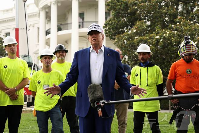 도널드 트럼프 미국 대통령이 18일(현지시간) 워싱턴DC 백악관 남쪽 잔디밭에 새 국기 게양대를 설치하는 작업자들이 지켜보는 가운데, 이란에 대한 직접 공격 여부 등에 대해 답하고 있다. 트럼프 대통령은 "할 수도 있고, 안 할 수도 있다며 상황이 매우 가변적임을 시사했다. 2025.06.18 ⓒ 로이터=뉴스1 ⓒ News1 류정민 특파원