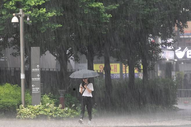 지난 16일 오후 서울 지역에 폭우가 내리는 가운데 한 시민이 서울 시청을 지나고 있다. /장련성 기자