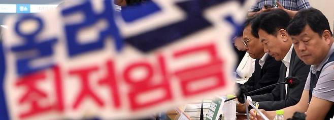 17일 세종시 정부세종청사에서 열린 최저임금위원회 5차 전원회의. 한 근로자 위원이 쓴 머리띠 뒤로 노사 위원들이 진지한 표정을 짓고 있다. ⓒ뉴시스