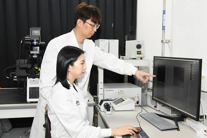 이진형 표준연 박사후연구원(위)과 이은숙 박사후연구원이 나노물질을 이용한 치료 실험 데이터를 검토하고 있다. 표준연 제공