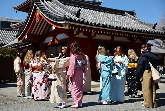 지난 3월 10일 일본 도쿄 아사쿠사구의 센소지 인근에서 일본 전통 의상을 입은 외국 관광객들이 기념 사진을 찍고 있다.로이터연합뉴스