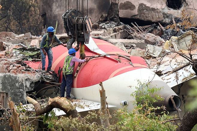 지난 14일(현지시각) 인도 서부 구자라트주 아마다바드 국제공항 인근에 추락한 에어 인디아 항공기 잔해 철거 작업을 하는 모습. 사진 EPA 연합뉴스