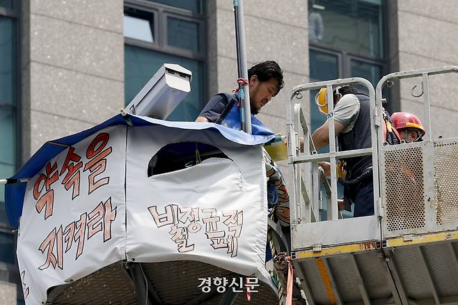 김형수 금속노조 거제통영고성조선하청지회장이 19일 서울 중구 한화빌딩 앞 철탑에서 2024년 단체협약서에 서명하고 있다. 문재원 기자