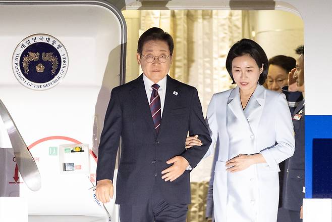 President Lee Jae Myung (left) and his wife Kim Hea Kyung disembark from Air Force One at the Seoul Air Base in Seongnam, Gyeonggi Province, Thursday morning. (Yonhap)