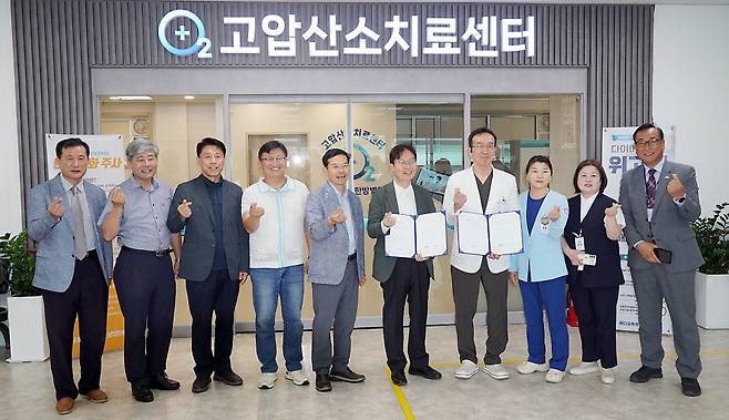 협약식 참석자들이 메디오투한방병원 고압산소치료센터 앞에서 기념촬영을 하고 있다.