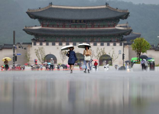 서울 지역에 소나기가 내린 지난 16일 서울 광화문광장에서 우산을 쓴 시민이 길을 지나고 있다. [사진 출처 = 연합뉴스]