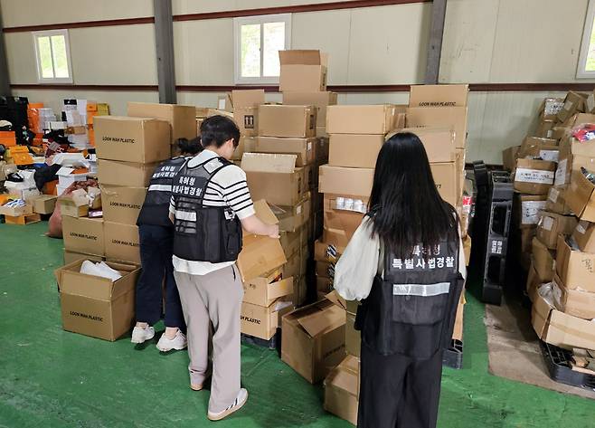 단속에 나선 특허청 상표특별사법경찰들이 창고에 보관된 위조 화장품을 확인하고 있다. 특허청 제공