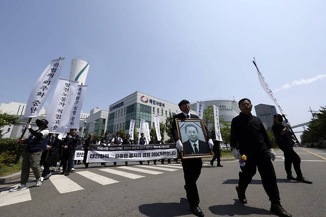 고인의 영정을 든 동료들과 영결식 참석자들이 김충현씨가 일하던 장소를 빠져나가고 있다.