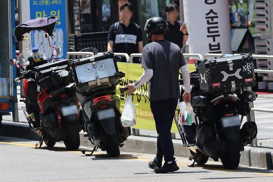 19일 서울 시내 식당가에서 배달 기사가 음식을 배달하고 있다. 이날 배달의민족 운영사 우아한형제들은 주문금액 1만원 이하 건에 대한 수수료를 전면 무료화하기로 발표했다. [뉴시스]