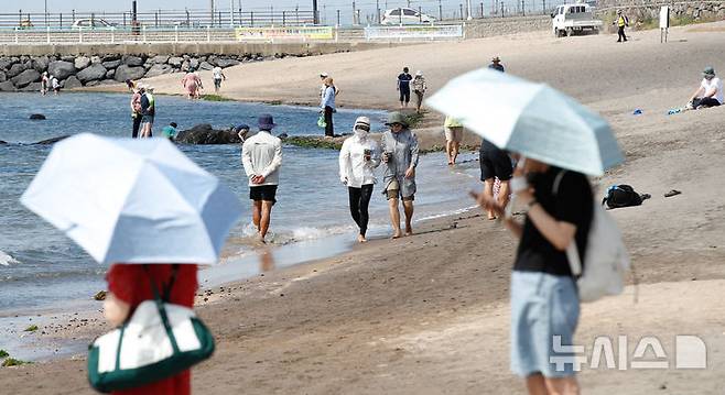 [제주=뉴시스] 우장호 기자 = 무더운 여름 날씨를 보인 19일 오후 제주시 이호테우해수욕장에서 관광객과 시민들이 시원한 바닷바람을 맞으며 더위를 식히고 있다. 2025.06.19. woo1223@newsis.com