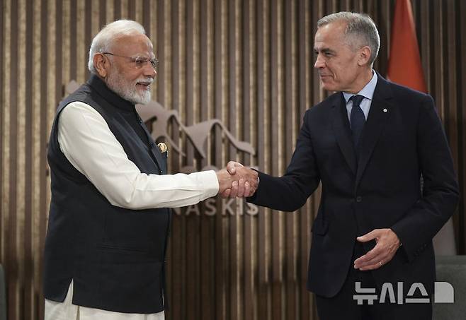 [카나나스키스(캐나다)=AP/뉴시스] 나렌드라 모디 인도 총리(왼쪽)와 마크 카니 캐나다 총리가 17일(현지 시간) 캐나다 앨버타주 카나나스키스에서 열린 주요 7개국(G7) 정상회의 회담 중 악수하고 있다. 2025.06.20.