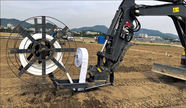유공관 매설기를 부착한 굴착기를 주행하면서 60㎝ 깊이에 유공관과 차수포를 동시에 매설하는 모습.