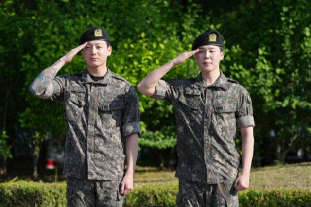 육군 현역 복무를 마치고 만기 전역한 그룹 방탄소년단(BTS)의 지민(오른쪽)과 정국이 지난 11일 경기도 연천군 연천공설운동장에서 거수경례를 하고 있다. AP통신