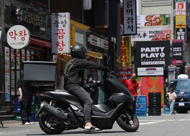 서울 강남의 한 번화가에서 배달 라이더가 이동하고 있다. 연합뉴스