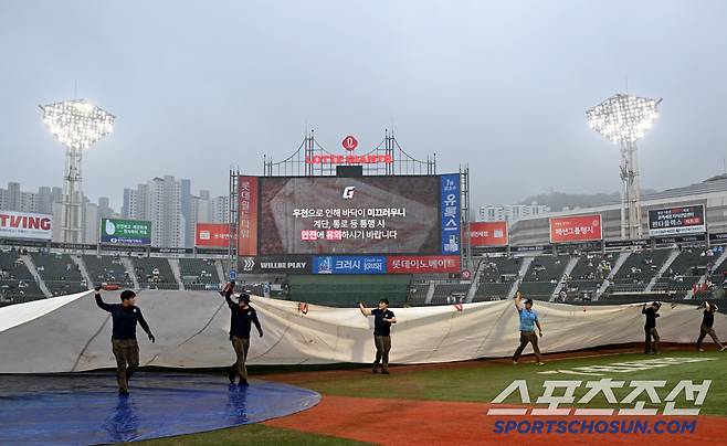 21일 부산 사직야구장에서 열린 삼성과 롯데의 경기, 경기 시작을 앞두고 경기장에 폭우가 내려 대형 방수포가 덮여지고 있다. 부산=허상욱 기자wook@sportschosun.com/2025.06.21/