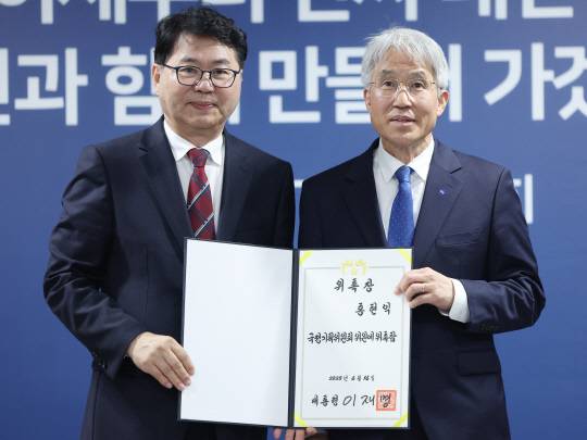 지난 6월16일 대통령직속 국정기획위원회 이한주(왼쪽) 위원장이 서울 종로구 정부서울청사 창성동 별관에서 열린 출범식에서 국정위 외교안보분과장을 맡은 홍현익 세종연구소 명예연구위원에게 위촉장을 수여한 뒤 기념촬영을 하고 있다. <연합뉴스 사진>