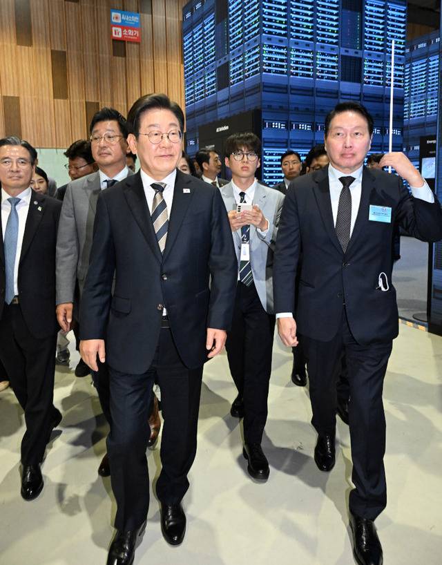 이재명 대통령이 20일 울산전시컨벤션센터에서 열린 ‘울산 인공지능(AI) 데이터센터 출범식’에 참석해 최태원 SK그룹 회장(오른쪽)과 이동하고 있다. SK그룹은 아마존웹서비스(AWS)와 손잡고 울산 미포 국가산업단지에 초대형 AI 데이터센터를 구축할 계획이다. 울산=대통령실사진기자단