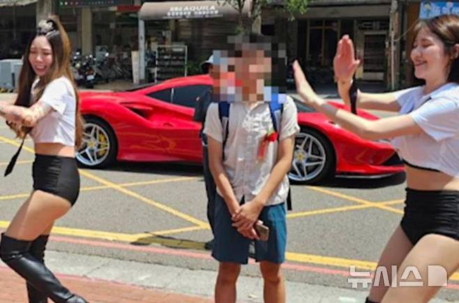 [뉴시스]대만의 한 부모가 아들의 중학교 졸업을 축하하기 위해 학교에 폴 댄서 두 명을 고용해 뭇매를 맞고 있다. (사진=SCMP)