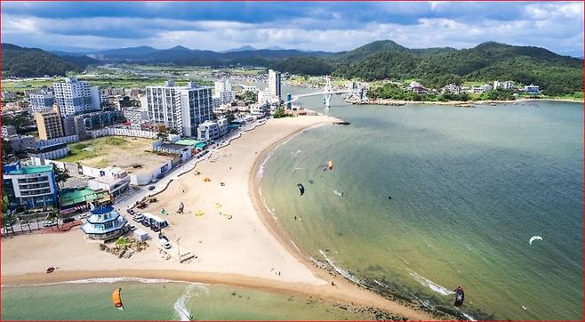 2025 진하해수욕장 드론 전경—부드러운 곡선형 백사장과 도심, 명선교 전경