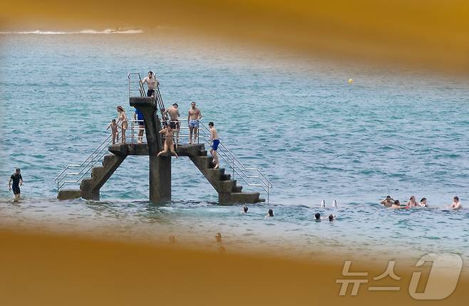 유럽 대륙에 때 이른 폭염이 찾아오며 프랑스 서부 일부 지역의 낮 최고 기온이 섭씨 38도, 체감온도는 40도를 기록한 가운데, 21일(현지시간) 프랑스 북서부 브르타뉴 지방의 생말로 해변을 찾은 시민들이 다이빙 등 해수욕을 하며 더위를 식히고 있다. 2025.6.22/뉴스1 ⓒ News1 이준성 기자