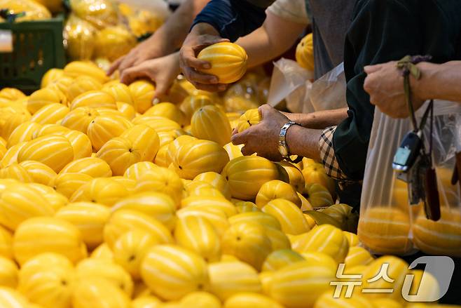 열무, 참외 등 여름 제철 농산물 가격이 줄줄이 오름세를 보이는 가운데 22일 서울 시내의 한 대형 마트 할인 매대에서 시민들이 참외를 고르고 있다. 2025.6.22/뉴스1 ⓒ News1 이승배 기자