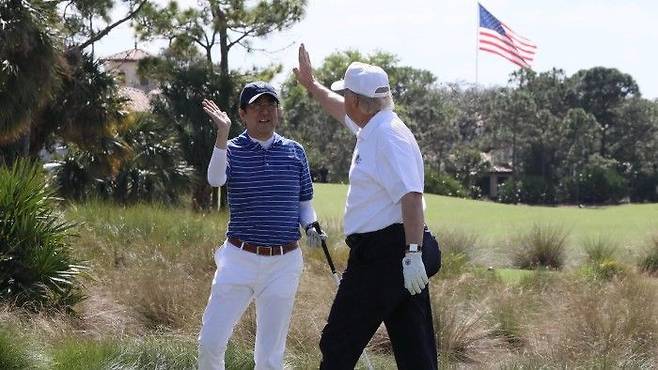 도널드 트럼프 미국 대통령과 아베 신조 일본 총리가 2017년 2월 미국 플로리다주 웨스턴 팜 비치 골프클럽에서 라운드 도중 하이파이브를 하고 있다. 로이터연합뉴스