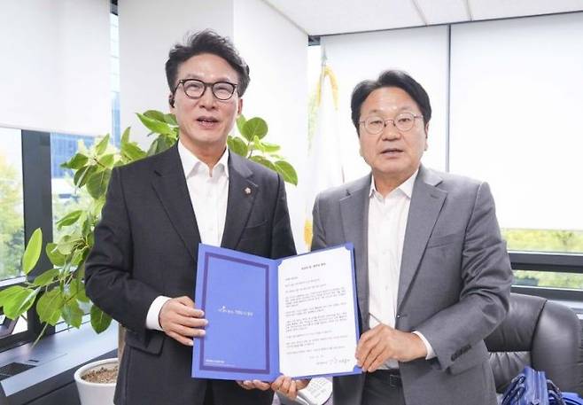 지난해 10월 광주 민간·군 공항 통합 이전에 나서줄 것을 요청하는 친서를 강기정 광주시장(오른쪽)과 김민석 수석 최고위원. 광주시 제공