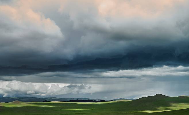 몽골 중부 지역. 엄청난 먹구름 사이로 드문드문 새어 나오는 빛이 녹색의 평원을 더욱더 아름답게 만들었다. 2016년/ 사진가 도재홍