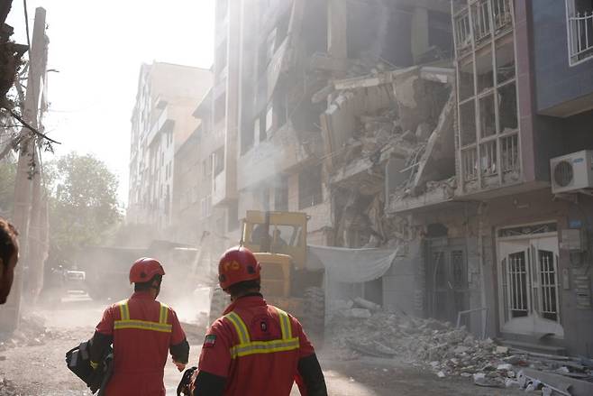 지난 14일(현지 시간) 워싱턴포스트에 따르면 이스라엘과 이란 양국의 보도와 발표, 타격을 받은 시설과 아직 피해를 입지 않은 시설의 위성 영상 및 동영상을 분석한 결과, 전문가들은 치명적 피해가 발생한 것은 아니라고 평가했다. 사진은 지난 13일(현지 시간) 이스라엘 공습으로 파괴된 이란 테헤란의 한 건물에서 구조작업이 이뤄지고 있다. 뉴시스