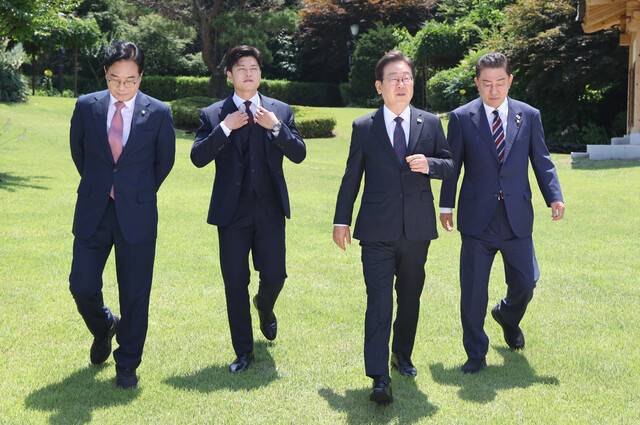 이재명 대통령이 22일 서울 한남동 관저에서 열린 여야 지도부 오찬 회동에서 기념 촬영을 마친 뒤 자리로 향하고 있다. 왼쪽부터 국민의힘 송언석 원내대표, 김용태 비상대책위원장, 이 대통령, 더불어민주당 김병기 당대표 직무대행 겸 원내대표. 대통령실사진기자단