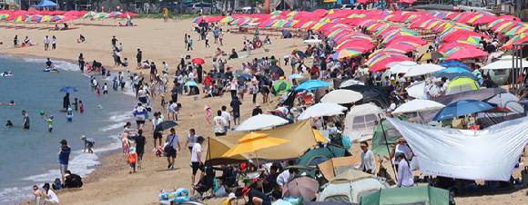 장마가 잠시 소강 상태를 보인 22일 인천 중구 왕산해수욕장을 찾은 시민들이 더위를 식히고 있다. 인천지역 주요 해수욕장은 지난 21일 중구 을왕리·왕산·하나개 해수욕장 개장을 시작으로 11개소가 순차적으로 개장한다. 2025.6.22 [사진=연합뉴스]
