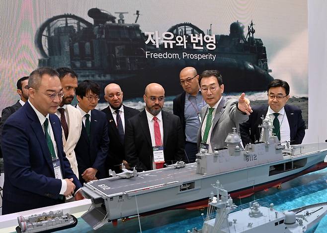 유상철 대표(오른쪽 둘째)가 MADEX 2025에서 해외 바이어들에게 HJ중공업이 건조한 함정을 설명하고 있다. HJ중공업