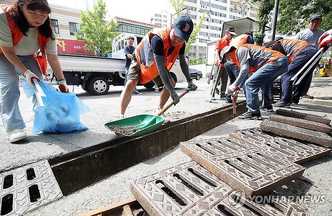 집중호우 대비 빗물받이 청소 (광주=연합뉴스) 21일 오전 광주 북구 문흥동 한 도로에서 북구청 청소행정과 직원들이 집중호우로 인한 침수 피해를 예방하기 위해 빗물받이 주변 환경 정화 활동을 하고 있다. 2024.6.21 [광주 북구 제공. 재판매 및 DB 금지] daum@yna.co.kr