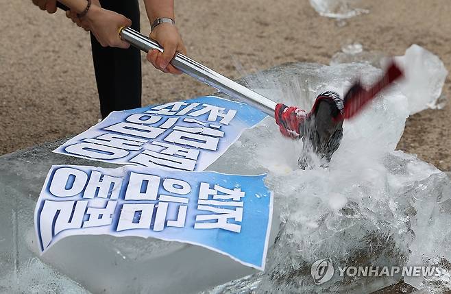 '최저임금 인상하라' (서울=연합뉴스) 김성민 기자 = 전국민주노동조합총연맹과 진보대학생넷 등이 10일 서울 종로구 광화문 월대에서 연 최저임금 확대 촉구 청년학생노동자 기자회견에서 참가자들이 최저임금 동결이라 적힌 얼음을 깨부수고 있다. 2025.6.10 ksm7976@yna.co.kr