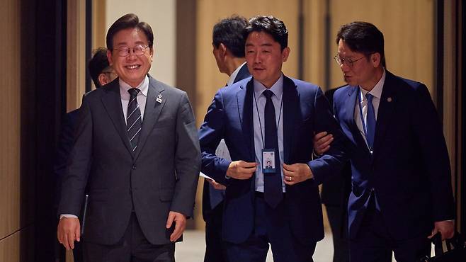 President Lee Jae-myung (left) walks with Chief of Staff Kang Hoon-sik (center) at the presidential office in Seoul on June 19, in this photo released on his official social media account the following day. /News1