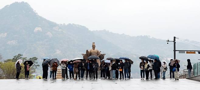 24일부터 25일까지 전국에 비가 내릴 것으로 예보됐다. 2025년 4월 14일 오전 서울 종로구 광화문 광장에서 우산을 쓴 외국인 관광객들이 이동하고 있다. /뉴스1