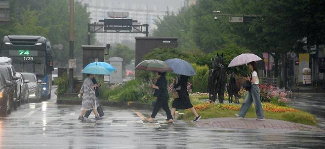 전북지역 곳곳에 호우주의보가 내려진 21일 전주시 백제대로에서 시민들이 우산으로 비를 피하며 길을 지나고 있다. 2025.06.21. 전주=뉴시스