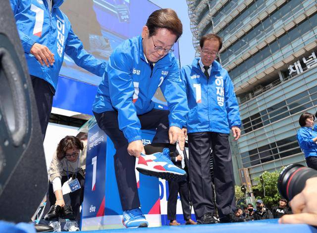 이재명 더불어민주당 대선후보가 제21대 대통령선거 공식 선거운동이 시작된 지난달 12일 서울 청계광장에서 열린 중앙선거대책위원회 출정식에서 운동화를 신고 있다. 공동취재