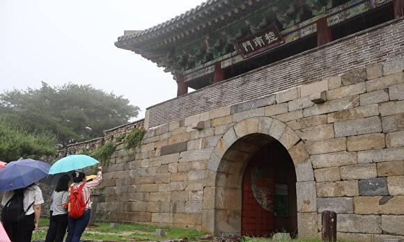 힐링투어 투어객들이 21일 해설사로부터 상당산성 남문에 대한 설명을 듣고 있다. [사진=윤재원 기자]